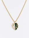A gold chain necklace featuring a monstera leaf pendant with dark green enamel accents, shown against a plain white background. plant jewelry